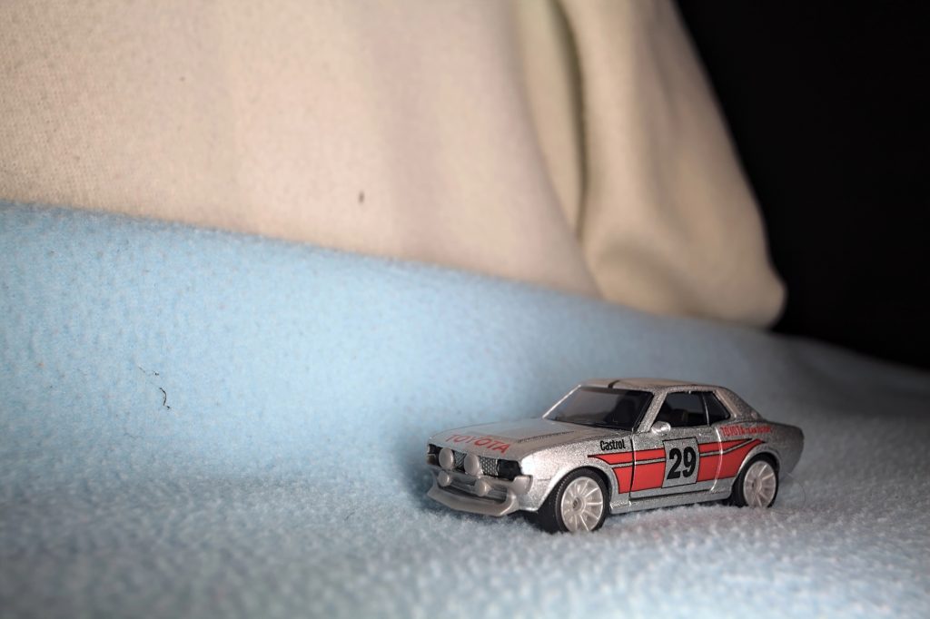 Voiture miniature de rallye Toyota Celica posée sur un plaid