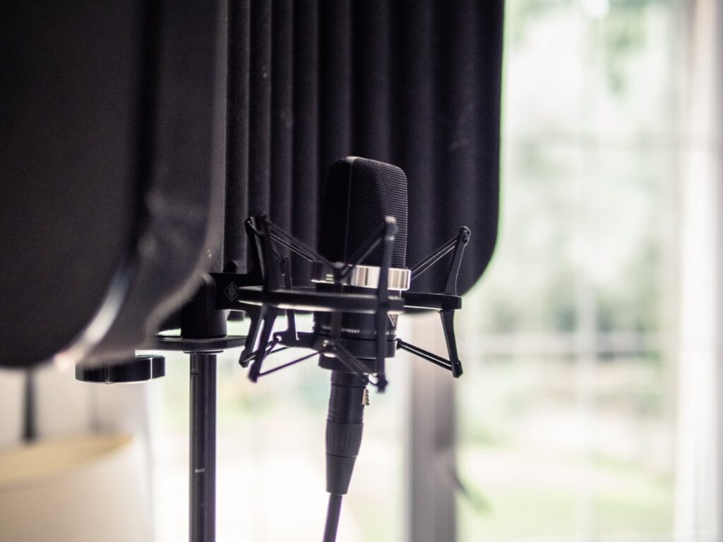 Micro de studio sur sa suspension, devant un écran acoustique, utilisé pour enregistrer les calendriers de l'Avent sonores